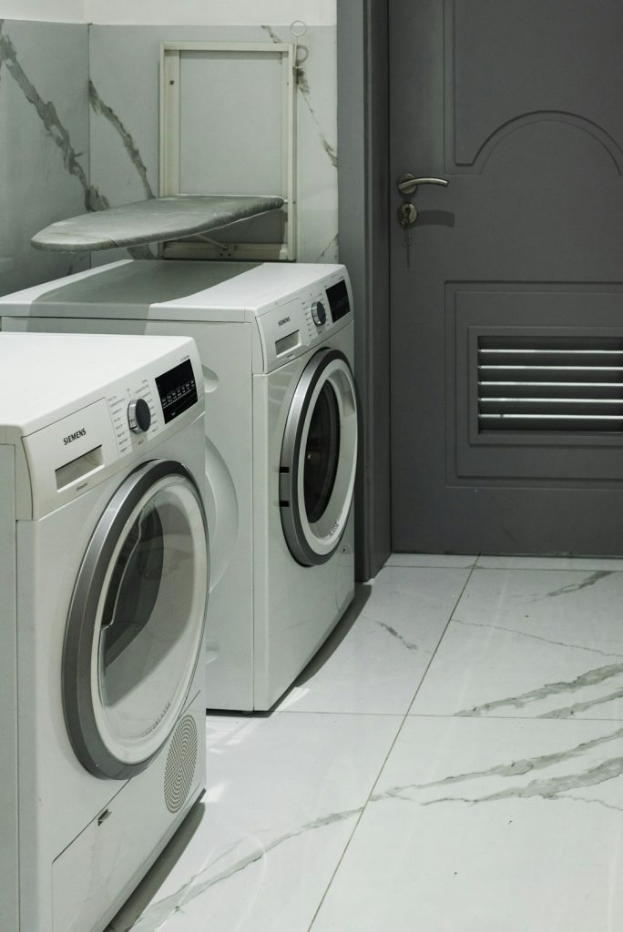 a-washer-and-dryer-sitting-next-to-each-other-fxpjw-wdmdk Interior pictures of a Stylish modern Washing Machine in a laundry area.