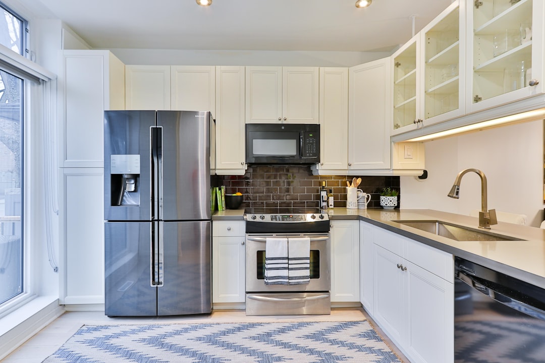 silver-french-door-refrigerator-beside-white-wooden-kitchen-cabinet-vagdhk-ki1c